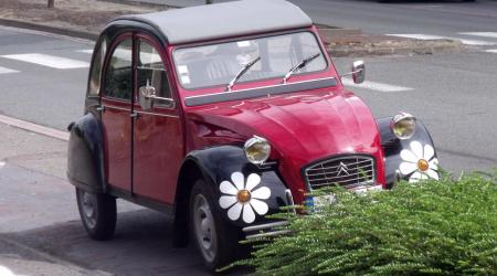 Voiture de collection « Citroën 2 Chevaux avec des stickers fleurs autour des clignotants »