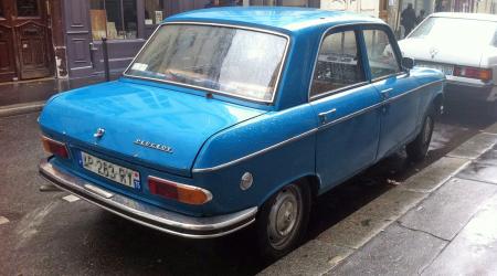 Voiture de collection « Peugeot 204 bleue sous la pluie vue de 3/4 arrière droit »